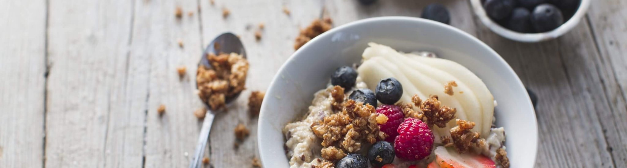 oat cereals porridge with fresh fruits on a wooden table